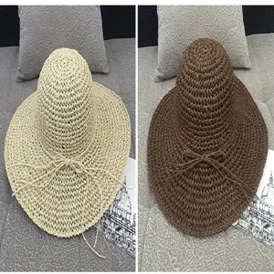 Detail view of wide brim straw sun hats in beige and brown for summer beach vacation