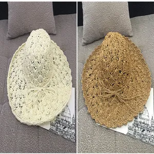 Detailed view of woven straw sun hats in cream and khaki with decorative bows