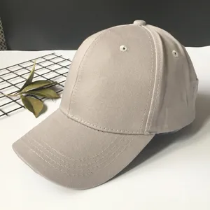 Close-up of a plain khaki cotton baseball cap showing side profile and visor detail