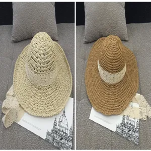 Detailed view of woven straw sun hats with white lace ribbon in beige and tan colors.