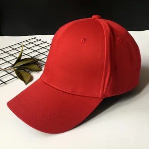 Detailed view of a solid red unisex baseball cap with curved brim and ventilation