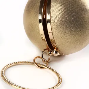 Spherical gold evening bag with luxury rhinestone circular handle close-up