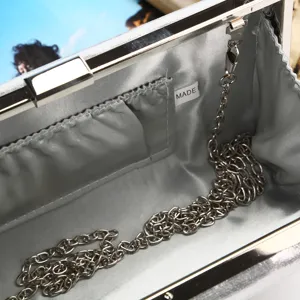 Elegant silver satin interior of a PU evening clutch bag with chain strap detail.