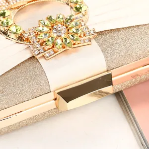 Detail shot of a champagne gold pleated evening clutch bag with sunflower rhinestone clasp