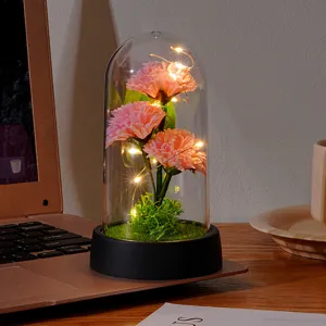 Exquisite artificial carnation flower glass dome night light with warm LED lights for cozy desk decor.