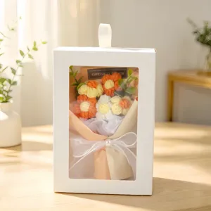 Detailed view of handmade knitted flower bouquet inside a white gift box with window