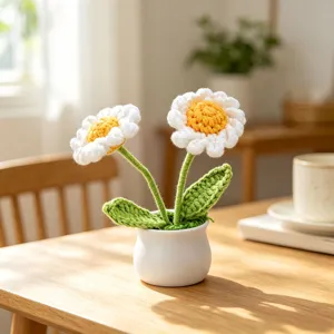 Close-up of handmade crocheted daisy flower pot ornament on a wooden table setup