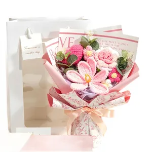 Hand-knitted crochet flower bouquet with pink roses and hearts in a gift bag
