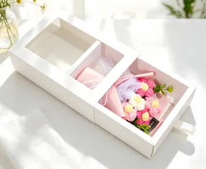 Detail view of a hand-knitted flower bouquet inside a white drawer gift box with window.
