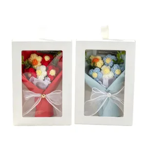 Handmade knitted yarn flower bouquets in red and blue themes within white gift boxes
