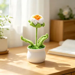 Handmade white crochet flower in white pot on wooden desk for aesthetic home decor