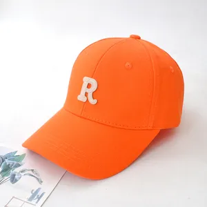 Close-up of a bright orange baseball cap featuring an embroidered letter R detail