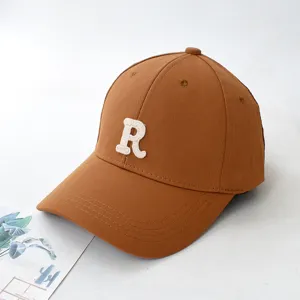 Detailed view of a brown baseball cap with an embroidered white R letter on the front
