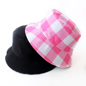 Detailed view of reversible bucket hats in solid black and pink gingham pattern