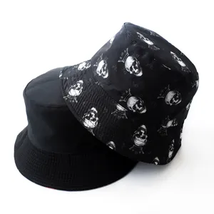 Close-up detail shot of the reversible bucket hat showing solid black and skull pattern.