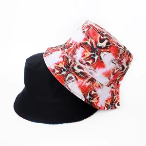 Vue détaillée du chapeau bob réversible avec un côté noir uni et un imprimé abstrait rouge.