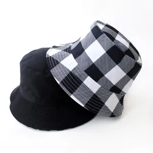 Stylish reversible bucket hat featuring solid black and black white plaid pattern
