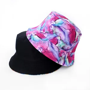 Chapeau bob réversible avec imprimé encre abstrait vibrant et côté noir uni élégant.