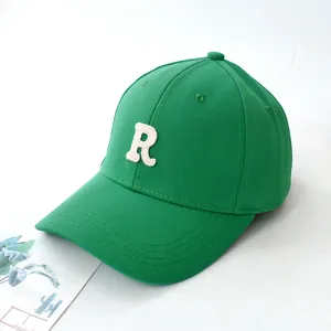 Close-up of a green baseball cap featuring a white embroidered letter R on the front