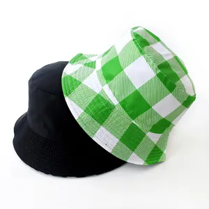 Reversible bucket hat featuring solid black side and green checkered pattern detail