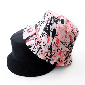 Reversible bucket hat detail shot showing stylish pink splatter print and classic black side.