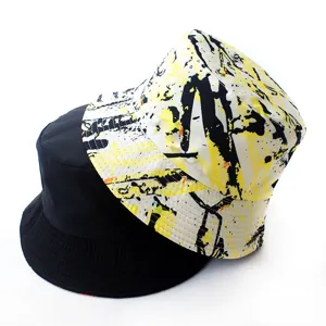 Close-up detail of reversible bucket hat, black and yellow graffiti design, sun protection.