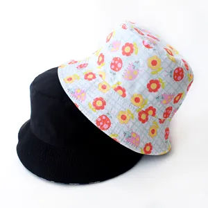 Close-up of double-sided bucket hats in solid black and colorful floral ladybug print.