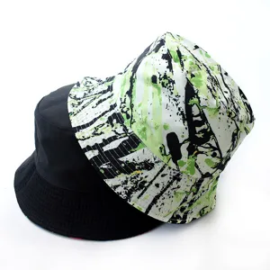Reversible bucket hat featuring solid black on one side and green splash ink on the other.