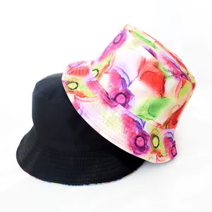 Détail de chapeau bob réversible avec impression florale colorée et option noire.