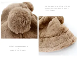Close-up of the thick brown plush fabric and cute pom-pom details on the bucket hat.