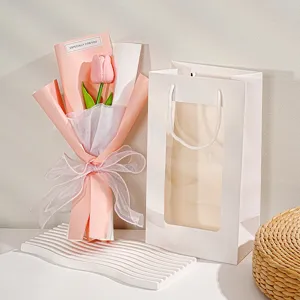 Gedetailleerd overzicht van pluche tulp bloemenboeket in roze wikkel met cadeautas, gift.