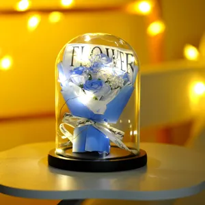 Vista dettagliata di rose di sapone blu in cupola di vetro con luci LED e nastro