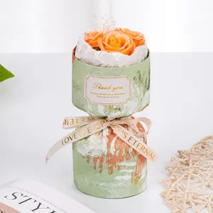 Primer plano de detalle de mini ramo de rosas de jabón con envoltorio verde y cinta.