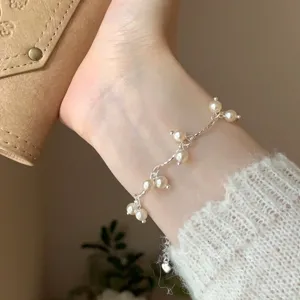 Primer plano detallado de una delicada pulsera de perlas de estilo francés en la muñeca