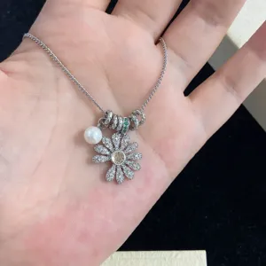 Primer plano de collar de margarita brillante con perlas y cristales