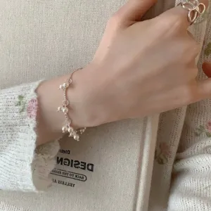Vista detallada de una elegante pulsera de perlas minimalista de estilo francés en la muñeca