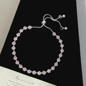 Primer plano de una brillante pulsera de burbujas de circonita rosa con cordón ajustable
