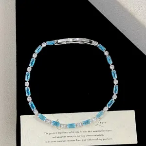 Elegant blue rectangular cubic zirconia bracelet displayed on a card with a gift ribbon