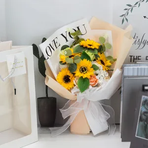 Detail of artificial sunflower bouquet with white gift bag and Love You wrapping paper