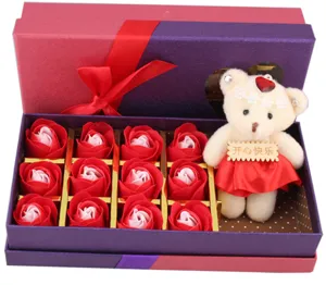 Gedetailleerd overzicht van de geschenkdoos met 12 rode zeeprozen en schattige teddybeer.