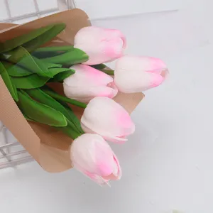 Gros plan d'un bouquet de tulipes artificielles roses dans un emballage esthétique.
