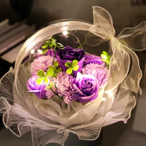 Gros plan de roses de savon violettes et d'œillets dans une boule acrylique avec LED