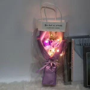 Primer plano de un ramo de flores de jabón moradas con luces LED en bolsa de regalo