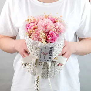Primo piano di un bouquet di fiori di sapone rosa in elegante confezione in tweed.