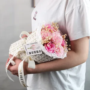 Dettaglio di un bouquet di fiori di sapone rosa in confezione tweed con nastro