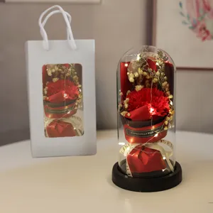 Close-up detail of the preserved red carnation flower in a glass dome with LED lights.