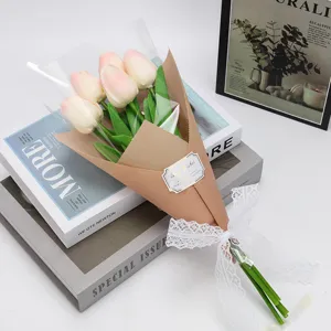 Détail d'un bouquet de tulipes roses artificielles avec nœud en dentelle et emballage