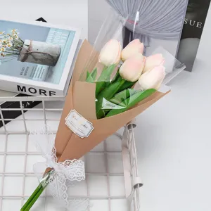 Gros plan d'un bouquet de tulipes roses artificielles emballé avec un nœud en dentelle