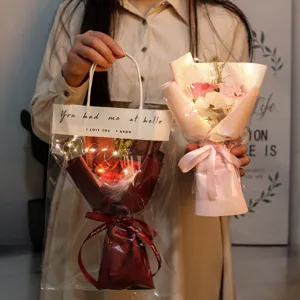 Primer plano de ramos de rosas de jabón con luces LED cálidas sostenidos por mujer