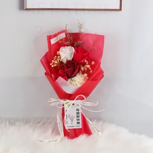 Detail van zeepbloemboeket met rozen en anjers in rode verpakking